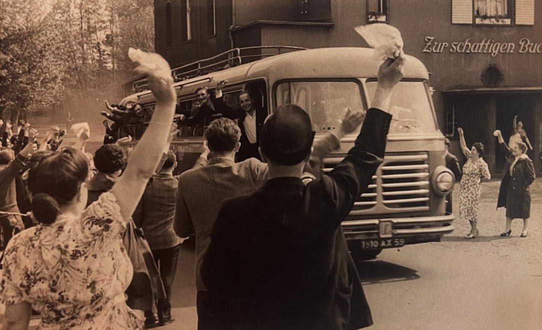 Abfahrt! Die Fortunen brechen zur Mannschaftsfahrt auf. Im Hintergrund, die Vereinskneipe „Schattige Buche“. 